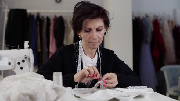 Portrait of a Seamstress Working on Details with Wedding Dress