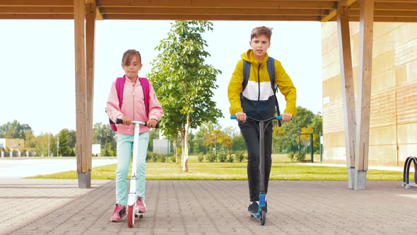 Children Riding Scooters at School Yard