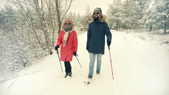 Couple Practicing Nordic Walking In Forest. Sticks Walking On Winter Wood. Sport Activities Healthy.