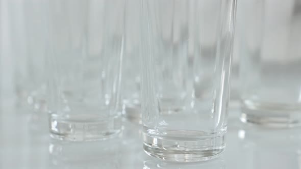 Close-up of shiny transparent  glasses on white background 4K 2160p 30fps UltraHD tilting footage - 