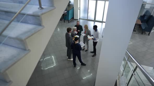 High Angle View Group of Business People Standing in Office Lobby Talking Smiling