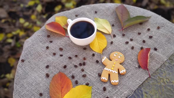 Gingerbread Man and Cup of Coffee Near Autumn Leaves