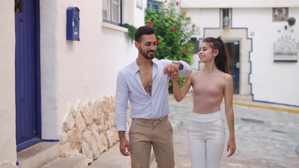 Stylish Hispanic Couple Kissing While Strolling in Town