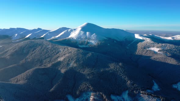 Aerial Winter view on Hoverla, peak of highest mountain of Ukraine. Winter Forest Snow Covered Trees