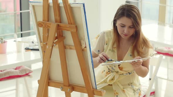 Female Artist Working at Her Workshop, Creating Beautiful Picture, Painting with Colorful Oils