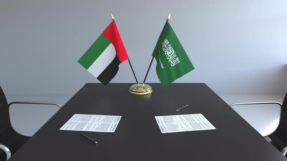 Flags of the United Arab Emirates and Saudi Arabia on the Table alt