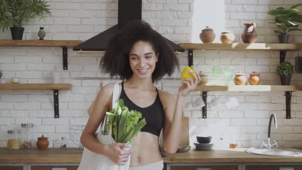 Lady with Pepper in Her Hands Promoting Healthy Eatting. Smilling and Looking at Camera