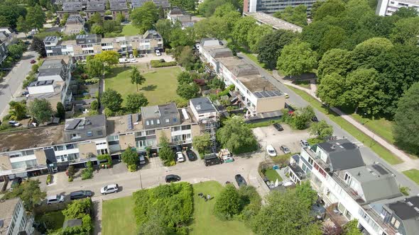 Drone flying towards rooftop under construction and renovation in a green suburban neighborhood