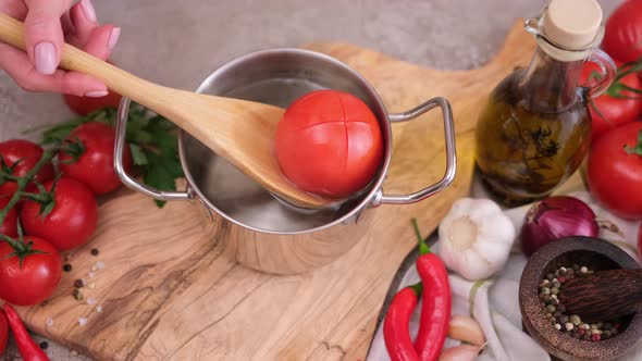 Woman Puts Tomato to Pot with Hot Boiling Water for Blanching