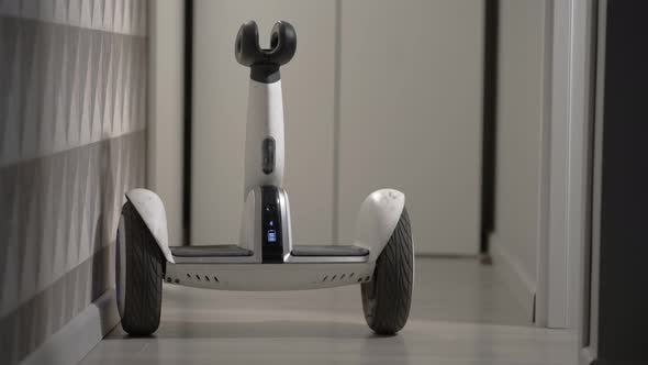 White Modern Gyro Scooter Gadget Balances Itself and Spins Without Intelligence in the Room and Hits