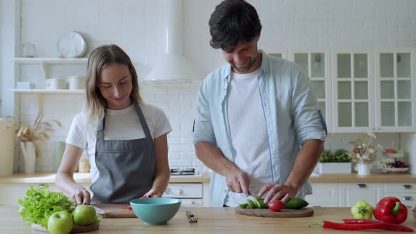 Young Happy Couple Is Enjoying and Preparing Healthy Meal in Their Kitchen
