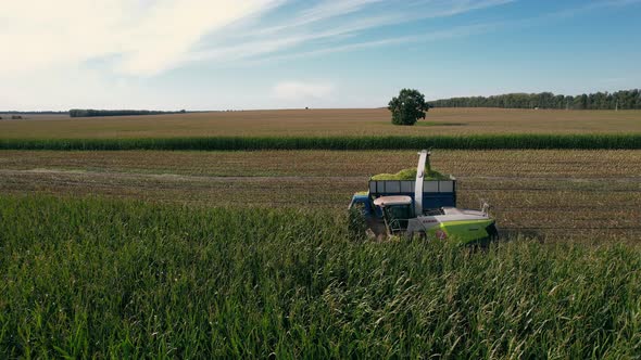 Semi truck and farm machines harvesting corn