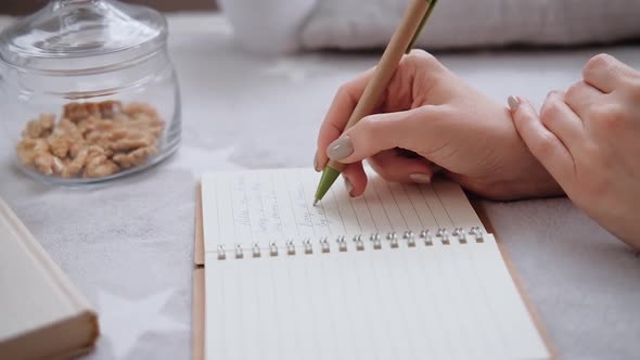 Young woman makes notes in her diary.