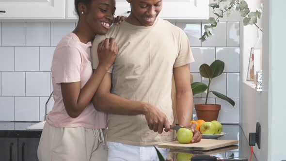 Cute Black Female Hugs Man From Back in Kitchen