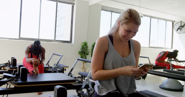 Woman using mobile phone in fitness studio 4k