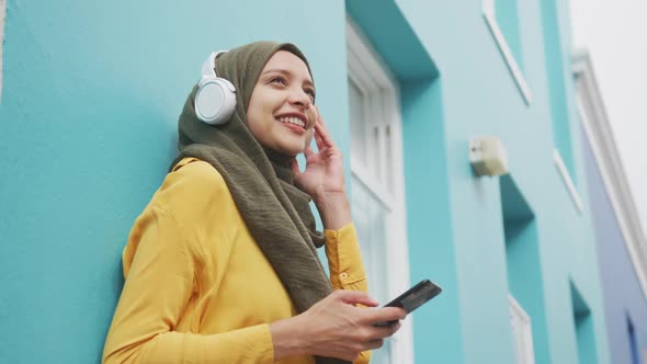 Woman wearing hijab with wireless headphone