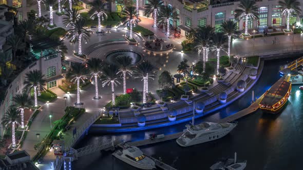 Dubai Marina Walk with Fountain and Palms Aerial Top View Night Timelapse