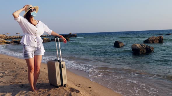 Woman in Protective Mask, Summer Clothes, Sunglasses and Sun Hat, Enjoying Warm Sunbeams, on Sea