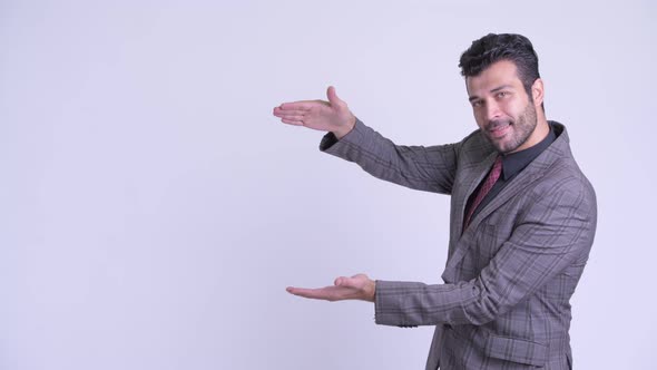 Happy Bearded Persian Businessman Snapping Fingers and Showing Something