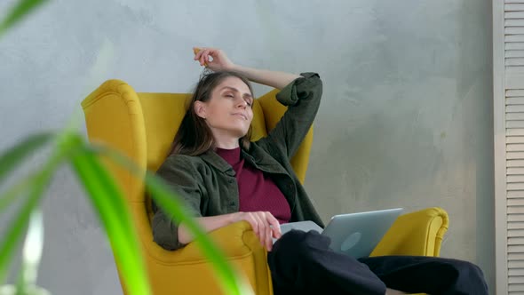 Woman relaxes with head massager. in modern interior.