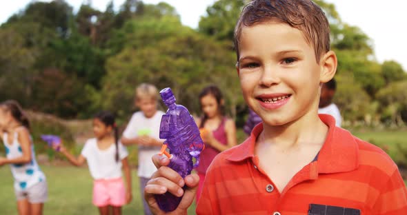 Portrait of smiling boy holding a water gun alt