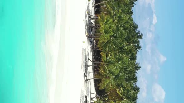 Tropical Island with Coconut Palm Trees and Turquoise Caribbean Sea with Floating Boats