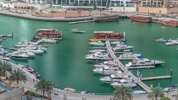 Luxury Yachts Parked on the Pier in Dubai Marina Bay with City Aerial View Timelapse