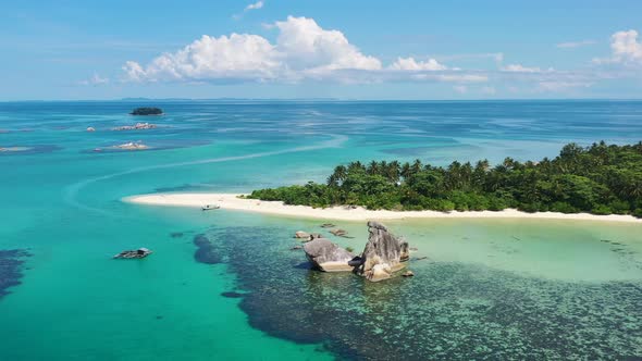 Aerial landscape panning shot of beautiful tropical islands and turquoise blue ocean on a sunny day