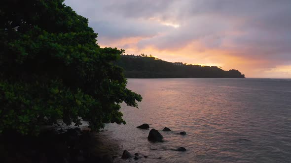 Fly Away Drone Aerial Reveal Breathtaking Sunset Moody Sky Above Kauai Hawaii Beach Shore