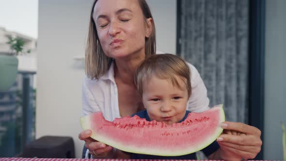 Young Mom with Daughter Eat Watermelon at Home