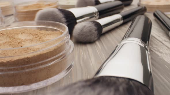 Cosmetics and Beauty Concept. Brush for Make-up with Powder on a Wooden Table