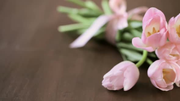 Light pink tulips on a wood background