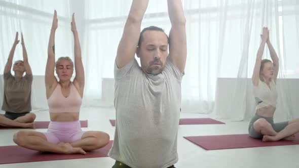 Five Young Women and Man in Yoga Class Meditation Exercises