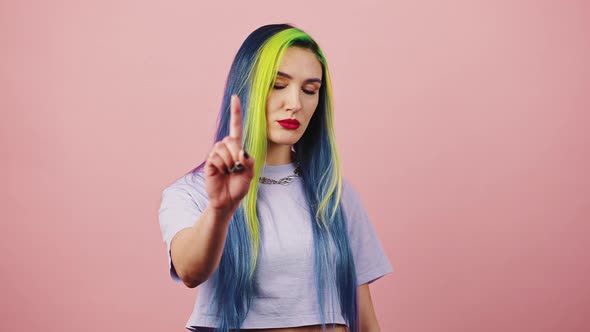 Young Strict Lady with Bright Rainbow Hairstyle Shaking Finger in Denial and Saying NO Scolding Over