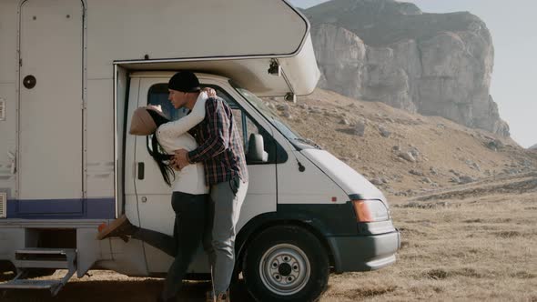 Couple Hugging and Kissing Standing By Camper Car While Traveling Outdoors Rbbro