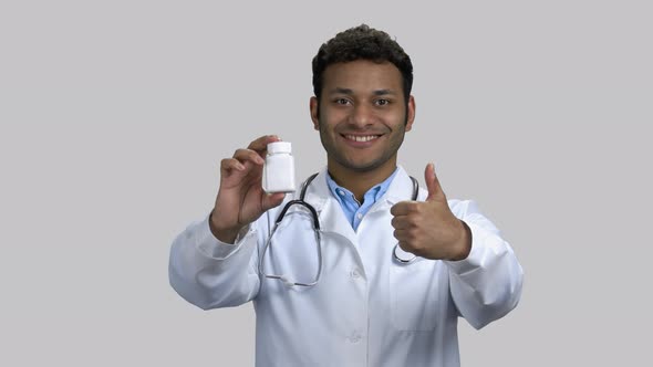 Portrait of Happy Darkskinnend Doctor with Medicine Bottle and Thumb Up