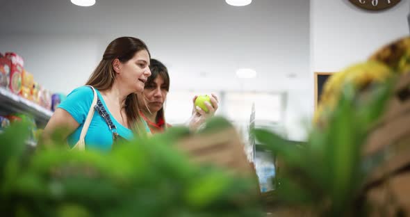 Female customer buying organic fruits inside eco fresh market