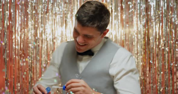 Young man blowing soap bubbles