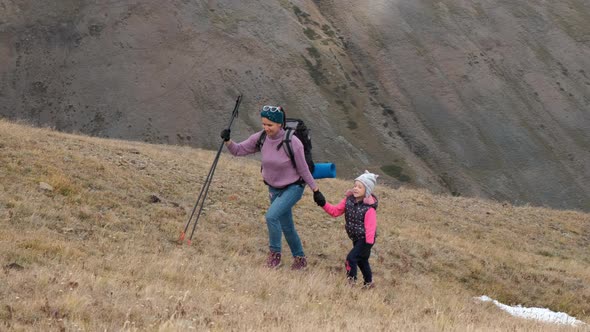 Female Hiker with Little Daughter in Mountains