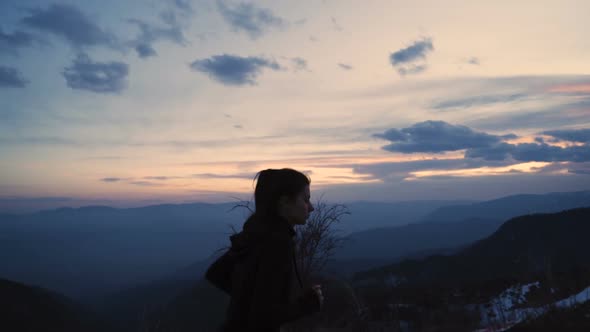 Girl Ponytail Waving As She Runs in the Mountain. Mountain Peaks with Beautiful Sunset Sky