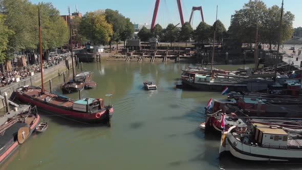 Drone fly over of the harbor of Rotterdam, Netherlands where boats and barges are docked.