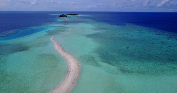 Tropical aerial tourism shot of a sandy white paradise beach and aqua blue ocean background 