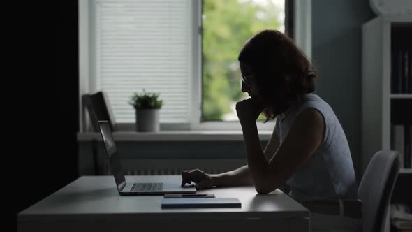 Woman Using Laptop Near Window