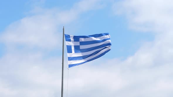 Flag of Greece in the Wind, White Clouds Sunny Sky Background 4K