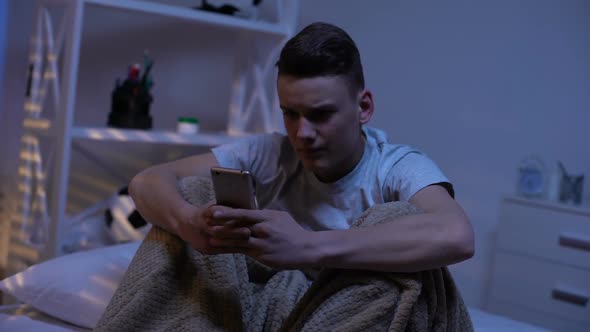Nervous Teenage Boy Typing on Phone, Bullying, Suicidal Internet Communities