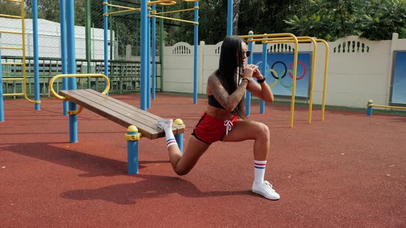 Sporty Beautiful Woman with Long Black Hair Doing Split Squat on the Street