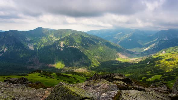 Polish Tatry Mountains timelapse clouds rolling over the land with shadows looking out into the dist