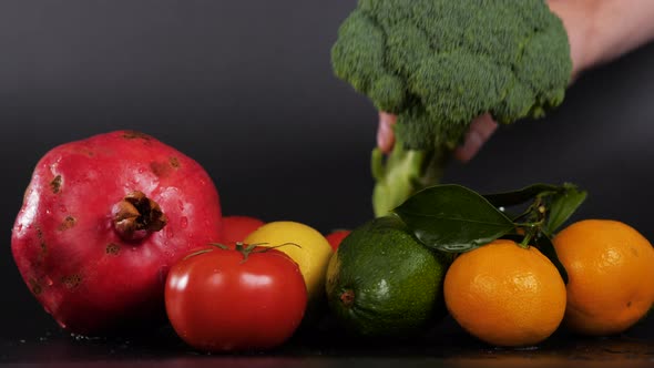 Multicolored Fresh Fruits and Vegetables on Black Background Tomato Broccoli Avocado Lemon Mandarin