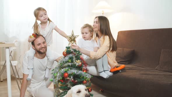 Portrait of Dog and Happy Family in the Background with Christmas Tree