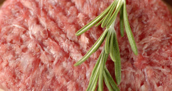 Raw Burger Meat with Rosemary Slowly Rotates